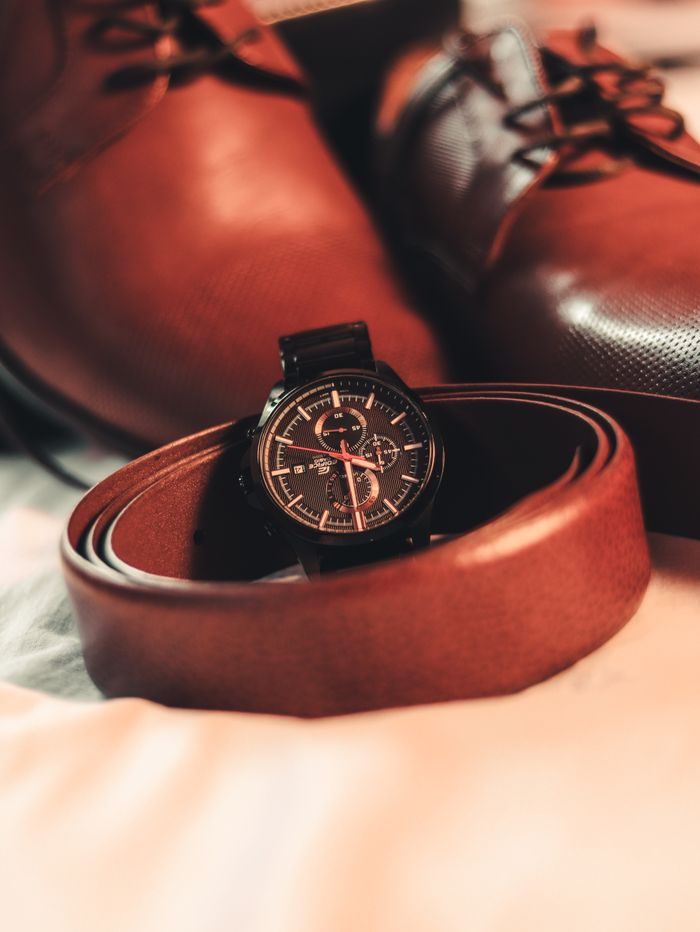 Stylish close-up of brown leather shoes, belt, and wristwatch for fashion-forward men.