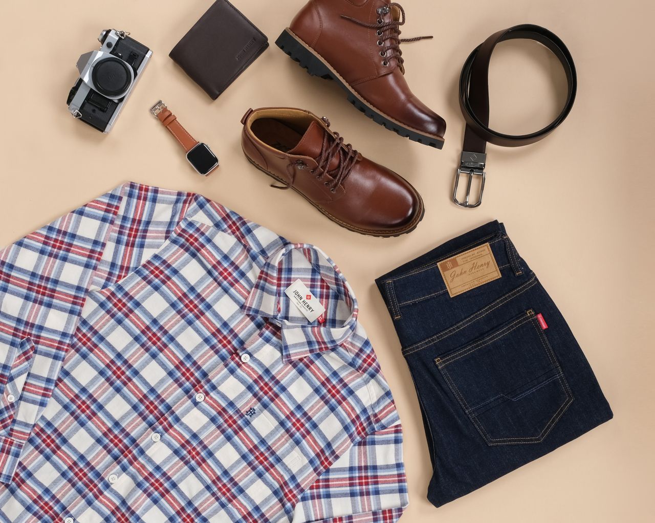 Stylish flat lay of men's outfit essentials with accessories on a beige background.